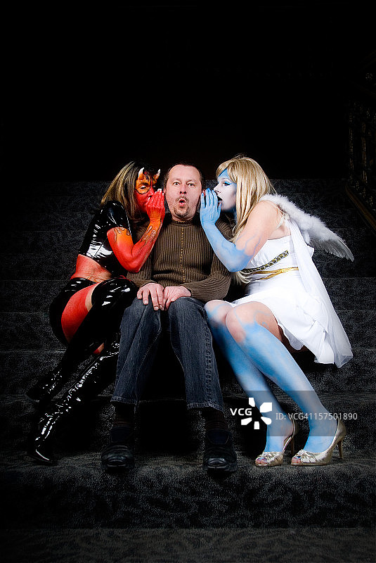 诱惑：天使与魔鬼在男人耳边低语图片素材