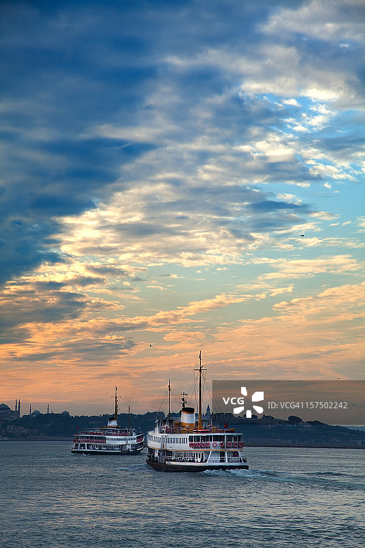 博斯普鲁斯海峡的日落时分，两艘客轮图片素材