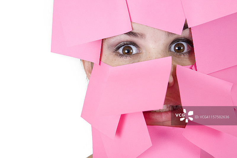 女人的脸被粉色便利贴覆盖图片素材