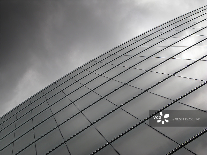 反射暴风云的现代玻璃建筑立面图片素材