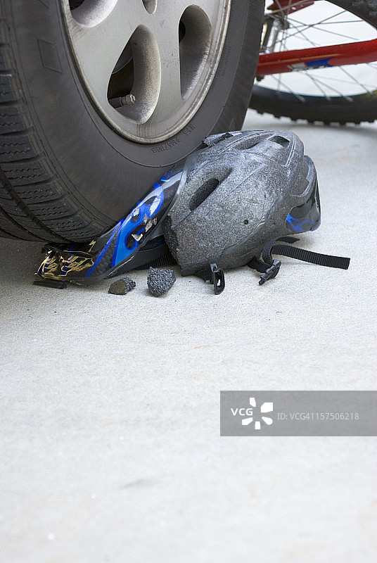 自行车事故中头盔被汽车轮胎压碎（竖版）图片素材