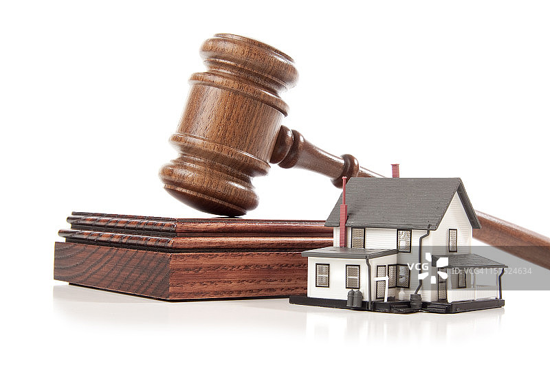 白色背景下模型房屋后的法槌和法槌垫图片素材