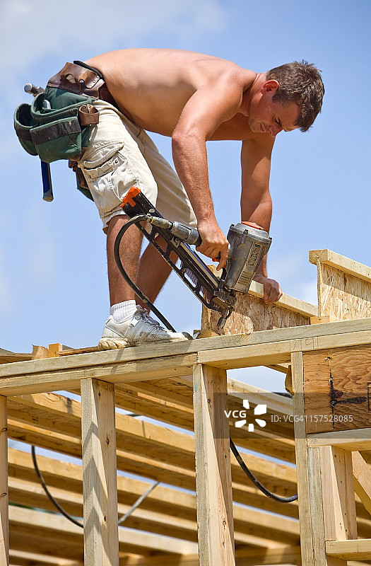 建筑工人使用气钉枪固定地板桁架托梁图片素材