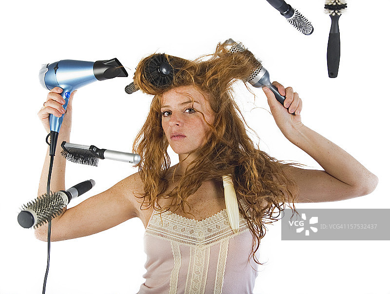 女孩用六把刷子和吹风机做发型图片素材
