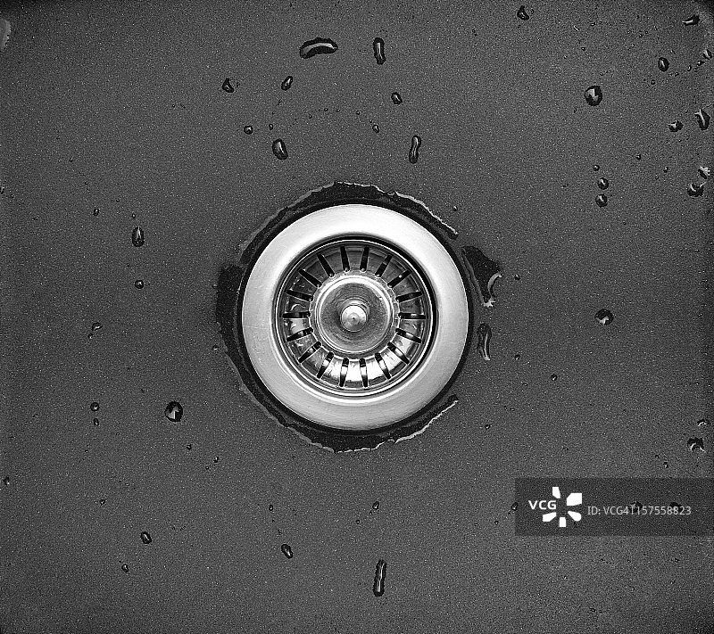 黑色石材厨房水槽排水口和钢塞特写图片素材