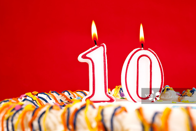 装饰生日蛋糕，有数字10蜡烛，红色背景图片素材