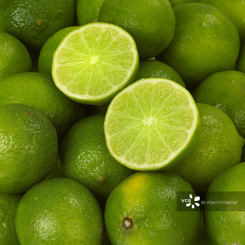 切开的青柠放在一堆新鲜青柠上图片素材