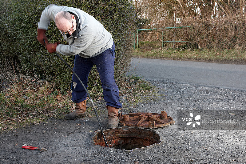 男人清理排水沟图片素材