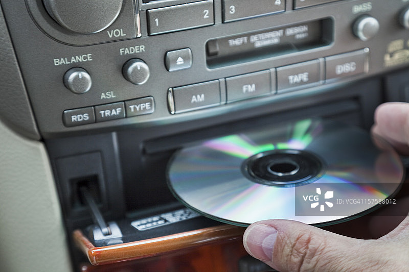 男人将CD放入汽车播放器图片素材