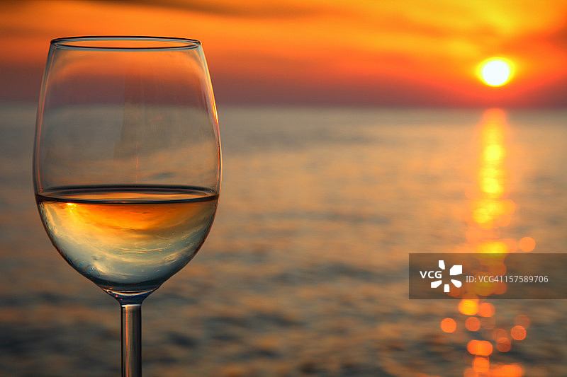 美丽的红色日落和一杯葡萄酒图片素材