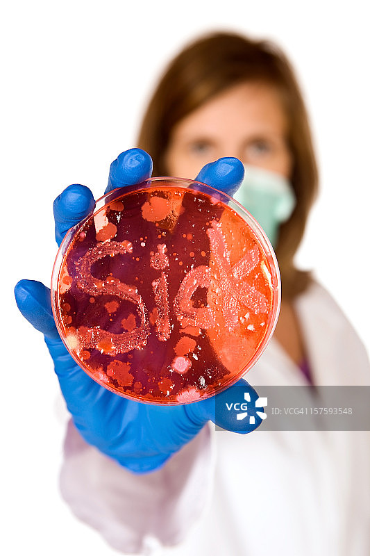 女医生拿着细菌写着“生病”的培养皿图片素材