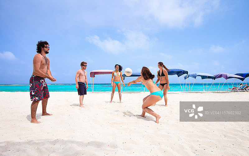 年轻人在海滩上打排球图片素材