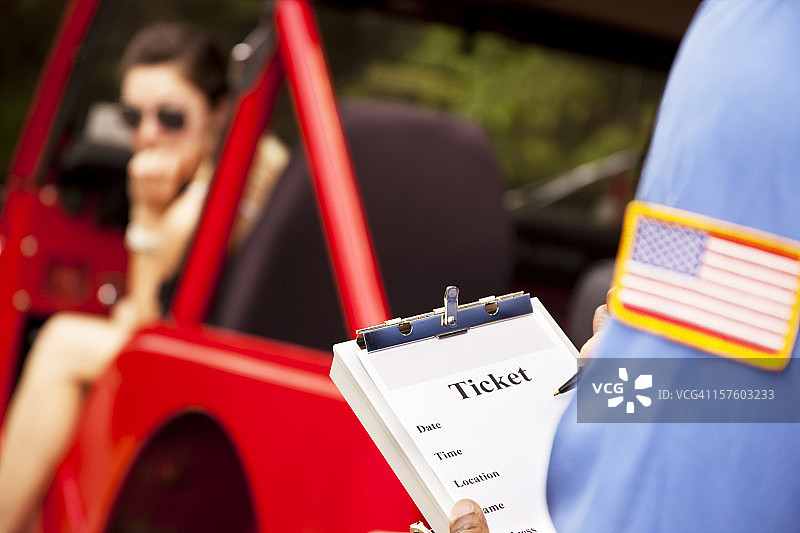 女司机在红色汽车里收到警察的交通罚单图片素材