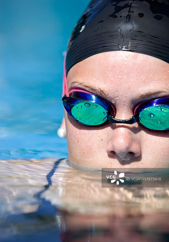 在蓝色泳池中休息的女子游泳运动员图片素材