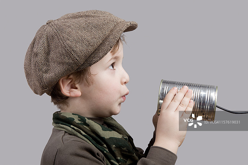 可爱的小男孩用罐头电话交流图片素材