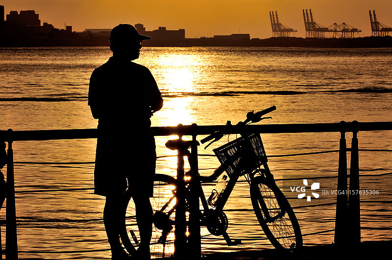 一位和他的自行车在一起的男人图片素材
