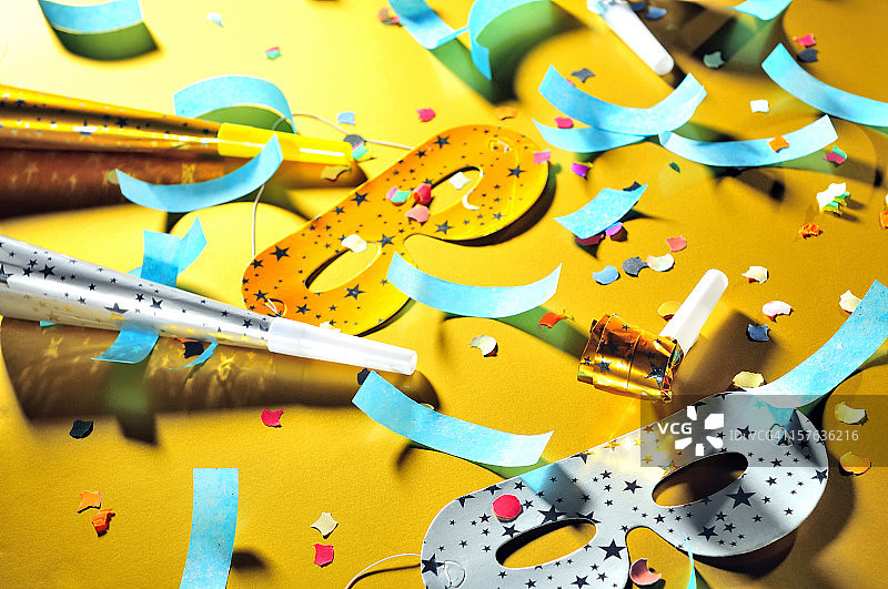 派对后的混乱：面具、口哨、喇叭和五彩纸屑散落在地板上图片素材