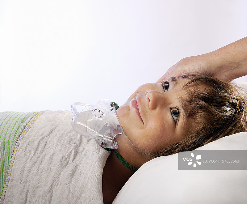 戴着氧气面罩在医院里微笑的小男孩图片素材