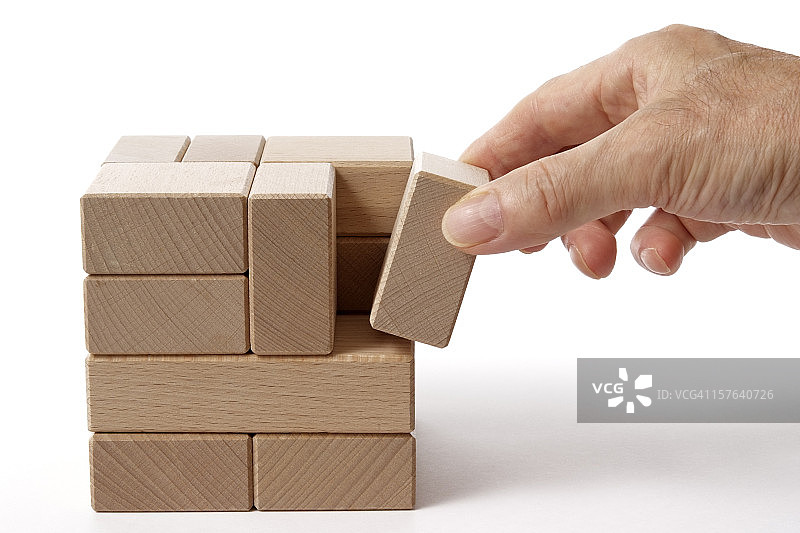 白色背景上手持木块的独立拍摄图片素材