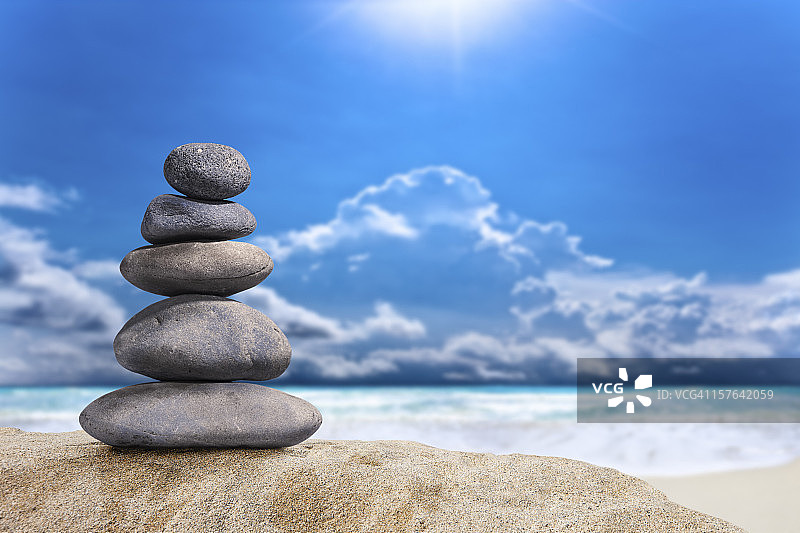 沙滩上堆叠火山卵石的魔法光芒图片素材