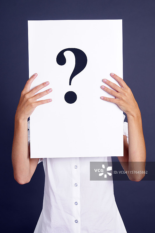 女人拿着遮住脸的问号纸图片素材