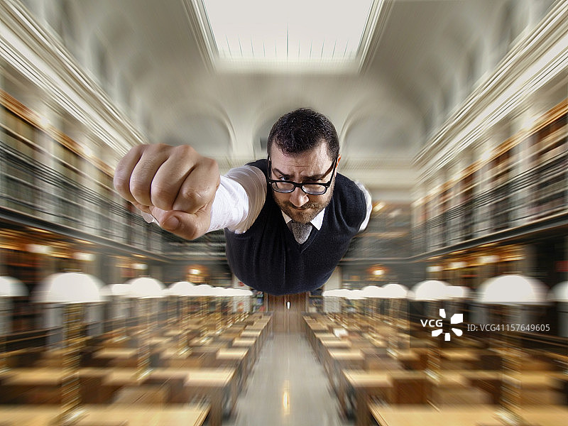 在图书馆飞翔的超人书呆子图片素材