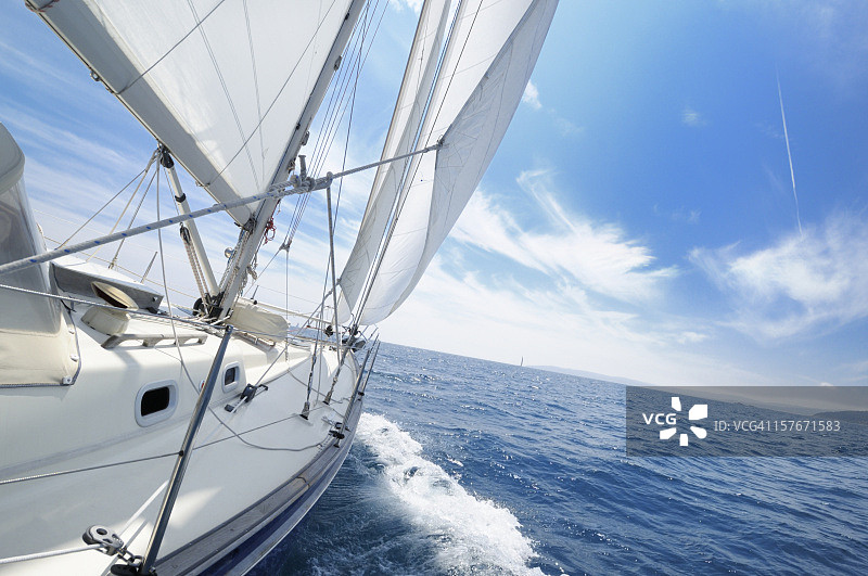 阳光明媚的日子里扬帆起航的游艇图片素材