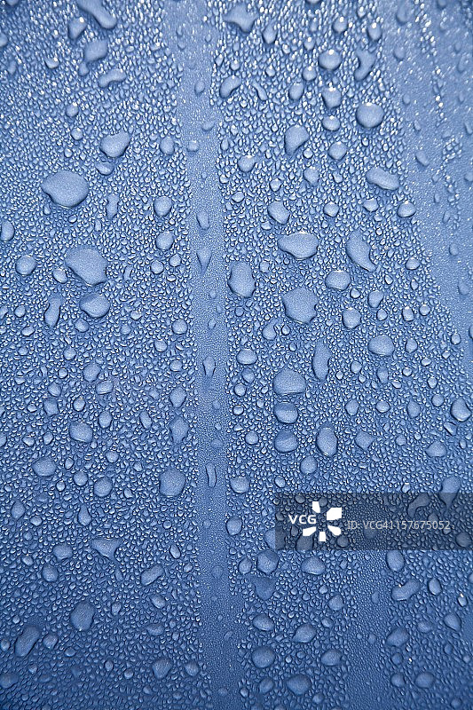 抛光蓝色引擎盖上的水滴图片素材