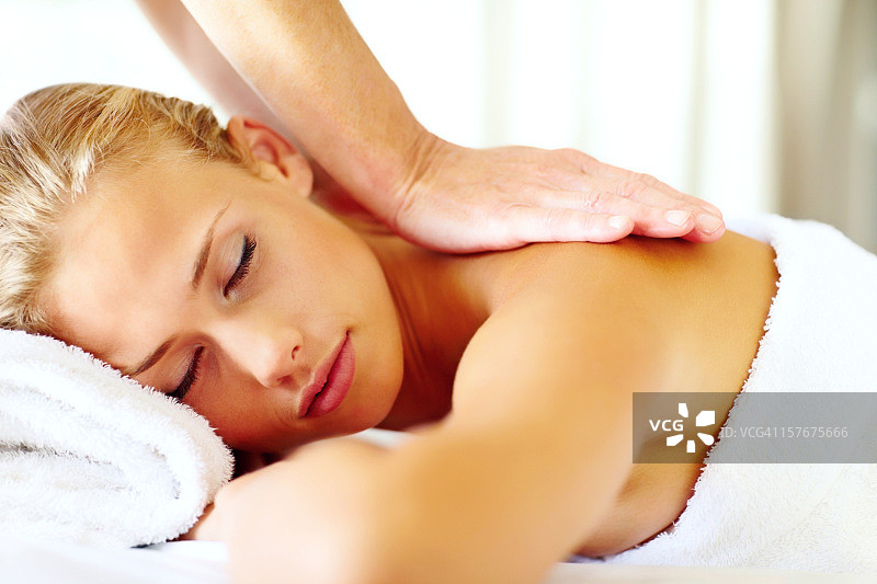 年轻女士接受身体按摩图片素材