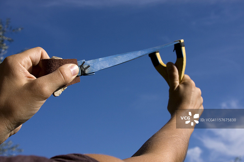 用弹弓将石头射向天空图片素材