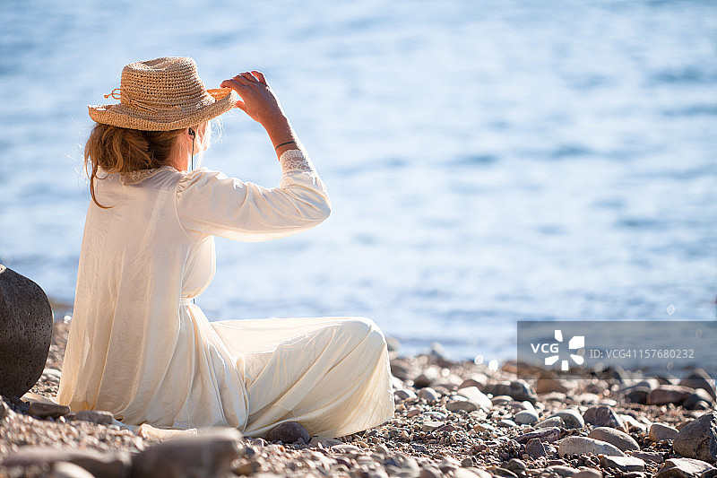 在湖岸边放松的白裙美女图片素材