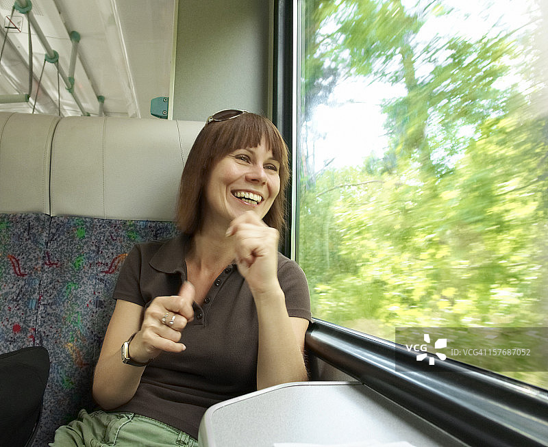 旅途愉快，火车旅行中的快乐女人，窗外景色图片素材