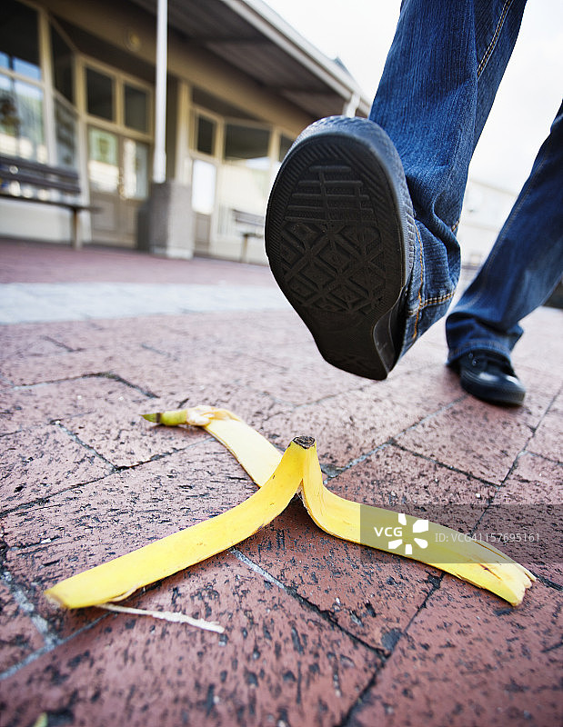 在铺砌的购物中心里踩到香蕉皮图片素材