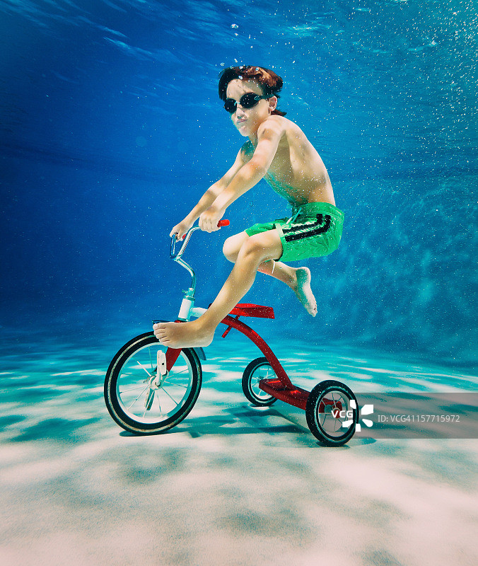 男孩在水下骑三轮车图片素材