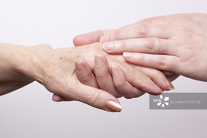 年轻的手握着年长女性的手图片素材