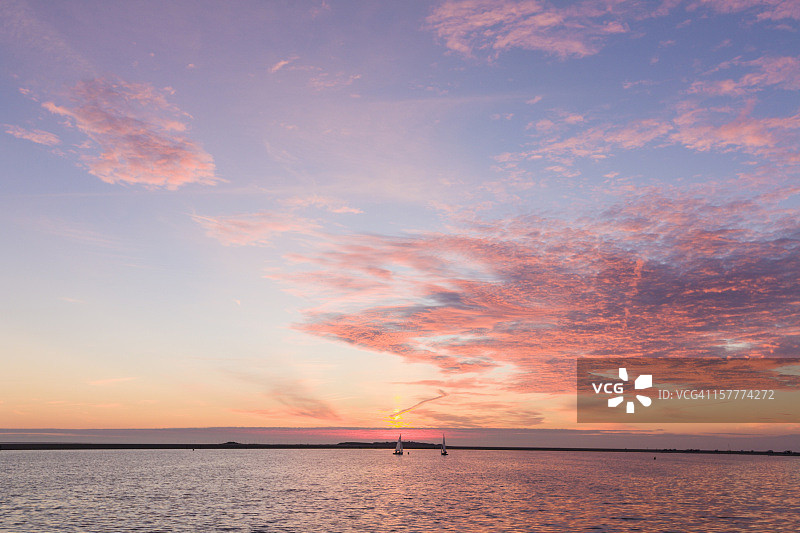日落时分湖上航行的小帆船图片素材