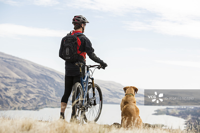 男子和他的狗一起骑山地自行车图片素材
