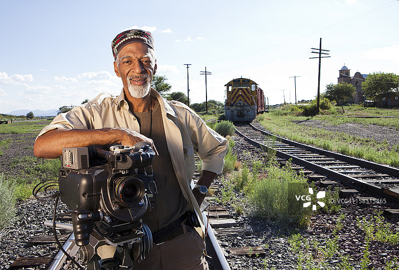 拿着胶片相机站在铁路附近的非裔美国人图片素材