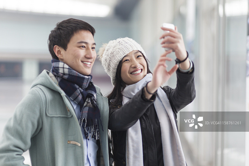 年轻夫妇用手机拍照图片素材