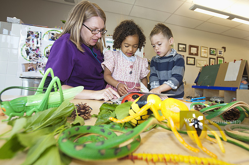 师生在教室里玩玩具昆虫图片素材