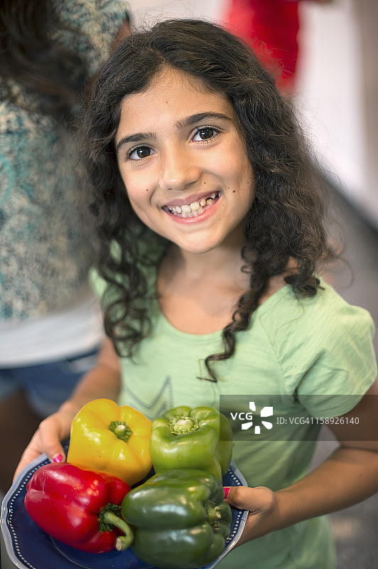 微笑的女孩拿着一碗辣椒图片素材
