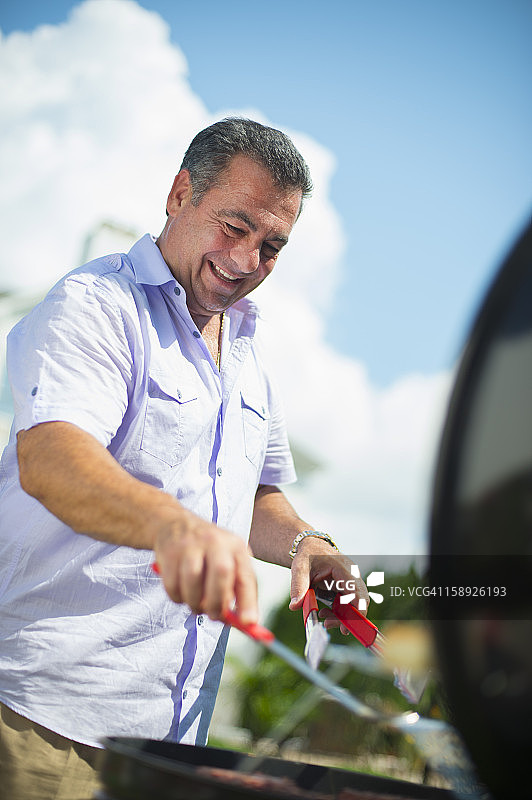 微笑的男人在户外烧烤图片素材