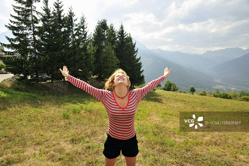 在山坡上喜悦跳跃的女人图片素材
