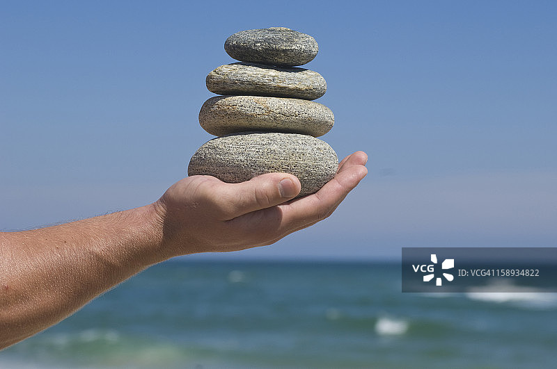 美国纽约州东汉普顿，手中握着一堆鹅卵石图片素材