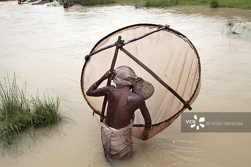 用圆形网捕鱼的村庄妇女图片素材