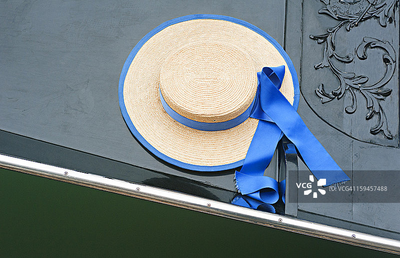 威尼斯贡多拉上的蓝色丝带草帽图片素材