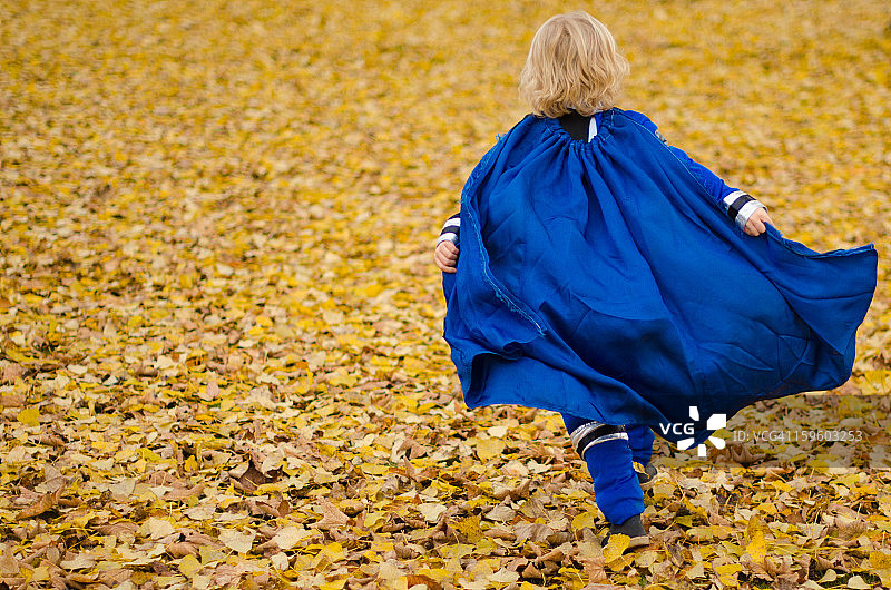 奔跑的金发小男孩，超级英雄斗篷在飞舞图片素材