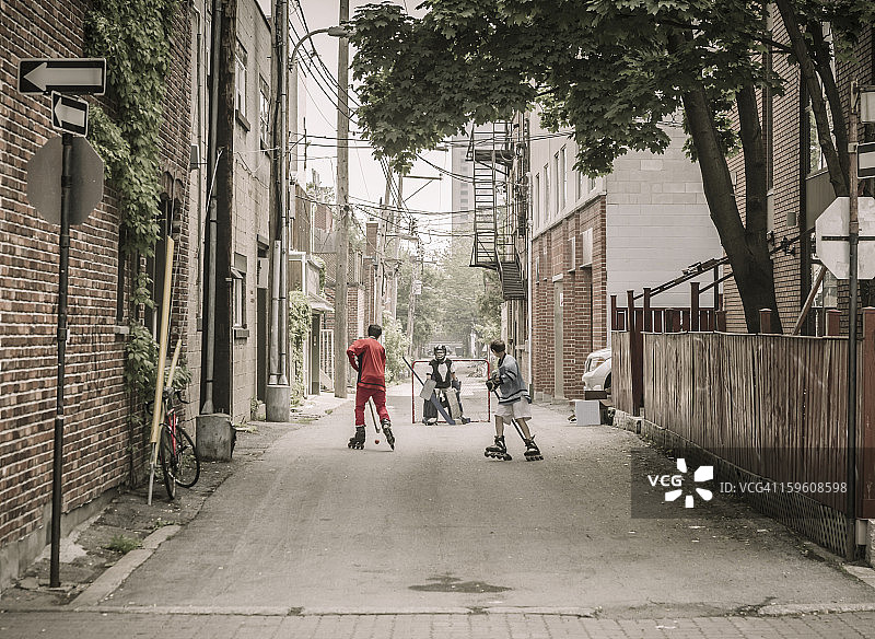 三个男孩在玩街头曲棍球图片素材