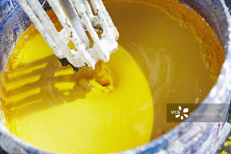 正在混合的一桶黄色油漆图片素材
