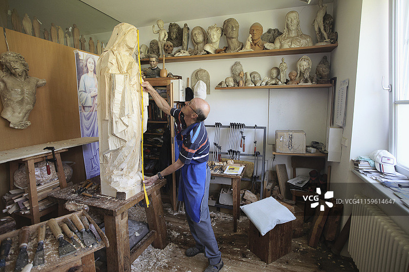 雕塑师测量木质雕像图片素材
